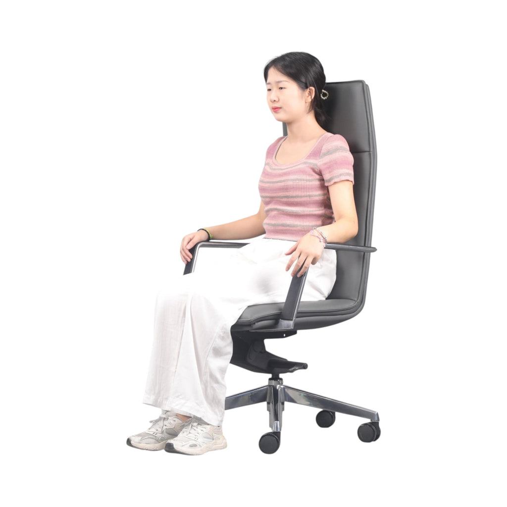 Xiaoyaozuo office chair executive high back chair in grey faux leather with chrome armrests and base, a woman sits in it.